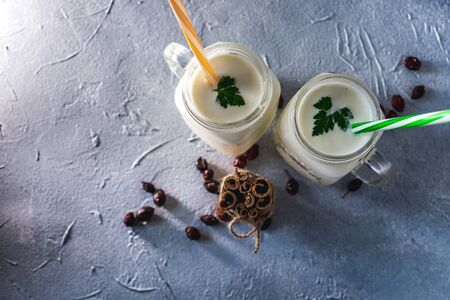 simple homemade kefir in a glass with spices and herbs on a gray background, copy space. Probiotic Ayranの写真素材
