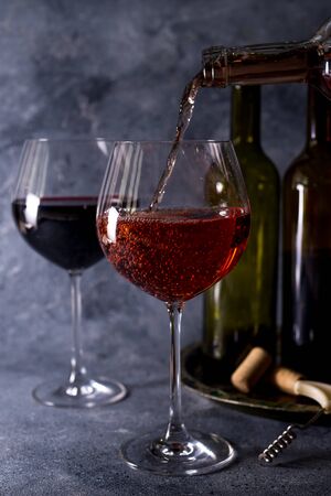 Red wine. Bottle and glass of red wine. Vintage style. Red wine on a black background. Design with space for your text.の写真素材