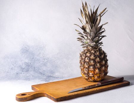 Pineapple on wood texture background. Whole and sliced ??tropical pineapple on a wooden board. Top view with place for your texの写真素材