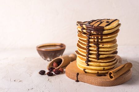 Fresh sweet pancakes with chocolate jam, cinnamon sticks and marshmallows on a gray background with place for your textの写真素材