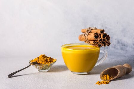 Golden turmeric milk on the white background with spices cinnamon and ingredientsの写真素材