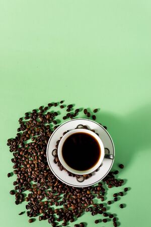 Coffee cup and coffee beans on a light mint backgroundの写真素材