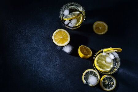 cut lemons with lemon slices and ice cubes against dark background. Top view. Close-upの写真素材