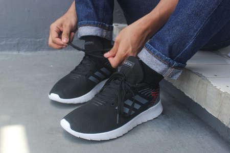 Depok, Indonesia - Mei 5, 2020 :  the man who ties adidas running shoesのeditorial素材