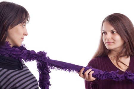 Two girls playing with a scarf on white