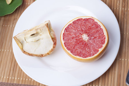 Dried apple and grapefruit in a dish on straw matの写真素材