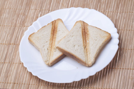 Toast in white plate on straw mat