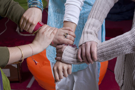 Indian women hands clasp around wrist, unity