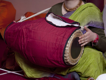 Krishna follower plays drum indoor