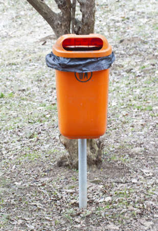 Orange trashcan in a public park.の写真素材
