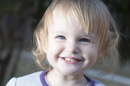 Baby playing in a park. Giving a smile.
