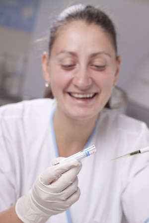 Woman taking sample from test tube with micro pipetteの写真素材