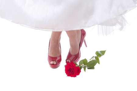 Bride feet in red shoes with rose compositionの写真素材