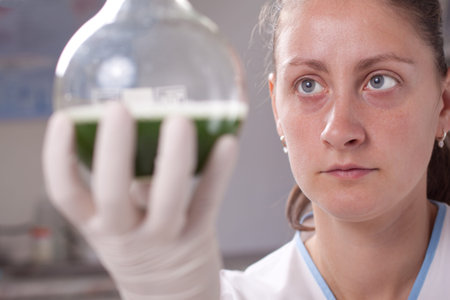 Woman examine bottle with chemical in laboratoryの写真素材