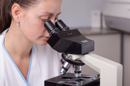 Young female doctor making research with microscope in laboratory.の写真素材
