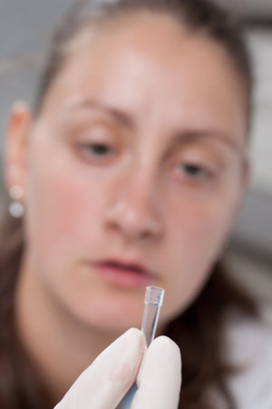 Woman examine blood sample in test container