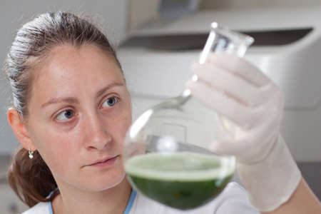 Woman examine bottle with chemical in laboratoryの写真素材