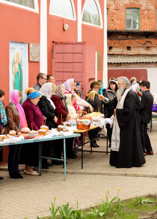 Kursk, 30.04.2016- Russian Orthodox Church priest sprinkle holy water  Easter cakes and eggs of...