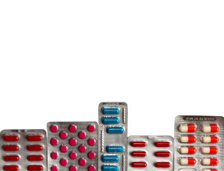 isolated pills packages on white background. backdrop with copy space. stack of many different multicolored blisters. red, blue and magenta drugs. heap of the tablets. horizontal background.の写真素材