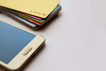 stack of bright colorful discount plastic cards and mobile phone. background with copy space.の写真素材