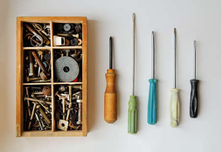 set of screwdrivers and wooden box with screws on a white backgroundの写真素材