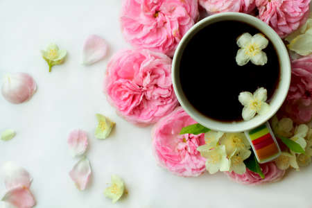 composition with cup of tea and rose and jasmine flowers on table. flat lay. top view.の写真素材
