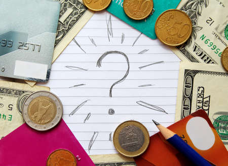 Question mark with dollar banknotes, euro coins, credit cards and pencil. Buisness concept.の写真素材
