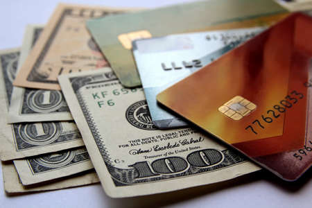 Stack of credit cards and american dollars, close-up view. Horizontal financial business background.の写真素材