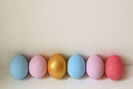 A row of pastel colored Easter eggs on white background. Festive easter background in minimalism style.の写真素材