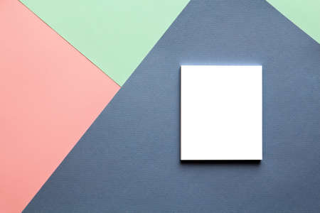 Abstract geometric watercolor paper background in soft pastel pink and blue trend colors with white notebook on it.の写真素材