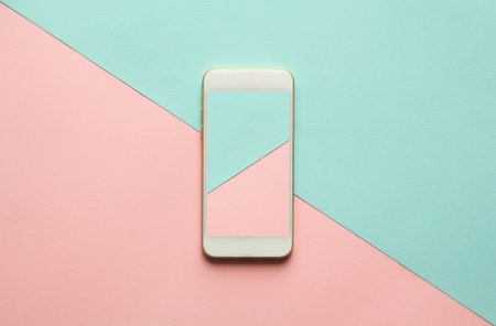 Blank screen white cellphone on diagonal pastel pink and blue background. Minimal concept, flatlay.