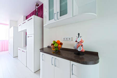 Kitchen with white facades and brown tilesの写真素材