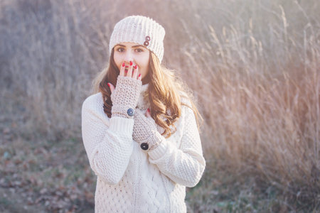 Winter portrait of a beautiful young woman in the sunny lightの写真素材