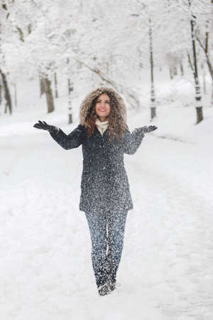 Winter portrait of a beautiful woman in the snowfallの写真素材