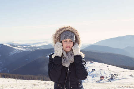 Winter view of a young woman admiring mountain landscape. Film filterの写真素材