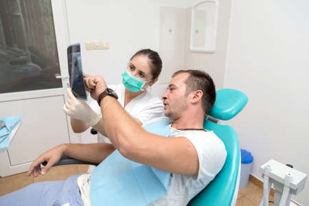 Dentist showing x-ray to a patient to the officeの写真素材