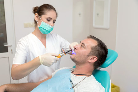 Dentist giving an injection of anesthesia to the patient. Young man at the dental clinic