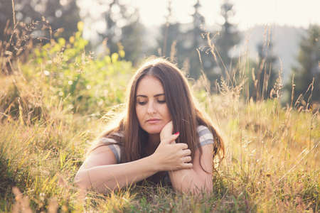 Young woman relaxing in the nature, at sunsetの写真素材