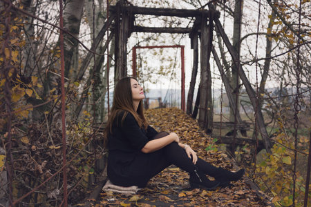 Autumn portrait of a young woman reading a book in the natureの写真素材