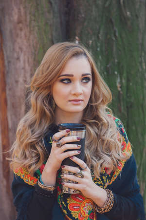 Winter portrait of a beautiful young woman, drinking hot teaの写真素材