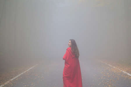 Red Riding Hood portrait in the autumn foggy forestの写真素材