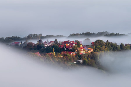 Foggy autumn morning on the beautiful green hills near Maribor, Slovenia. Scenic landscape and...