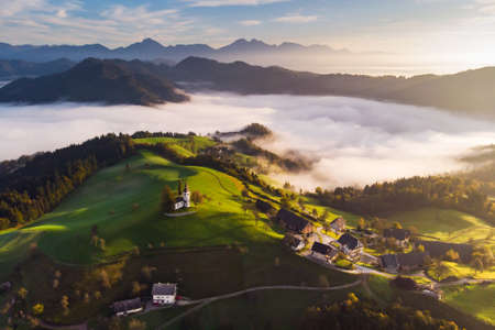 Autumn landscape of a beautiful church on the top of a hill, in Sloveniaの写真素材