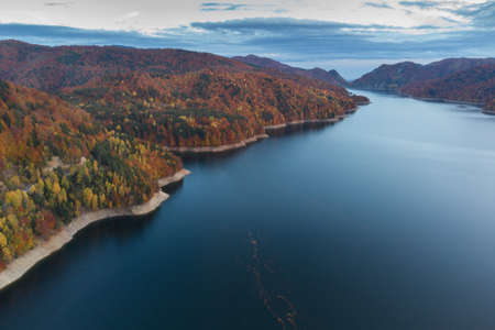Aerial view of colorful mountain road, at Vidraru Dam - Transfagarasan Highway, Romania, during autumnの写真素材