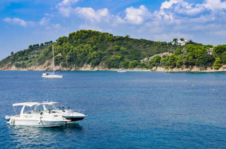 Sea background with white boats and a green islandの写真素材