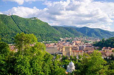 Old city of Brasov in Transylvania region of Romania with a medieval center full of rich historic and cultural monuments situated at the foot of the Tampa hill on a sunny summer day in a view from aboveの写真素材