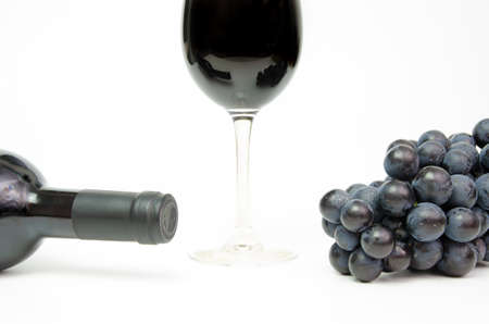 Red wine glass silhouette with a bottle neck and grapesの写真素材
