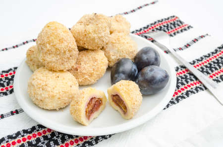 Traditional plum dumplings with prunes on a traditional romanian table clothの写真素材