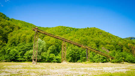 An old abandoned industrial concrete factory in a isolated wild area with a forest on the backgroundの写真素材