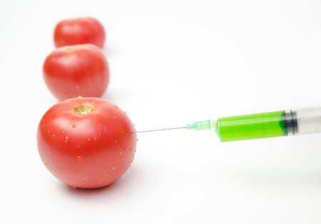 Tomatoes being injected with toxic artificial growth substancesの写真素材